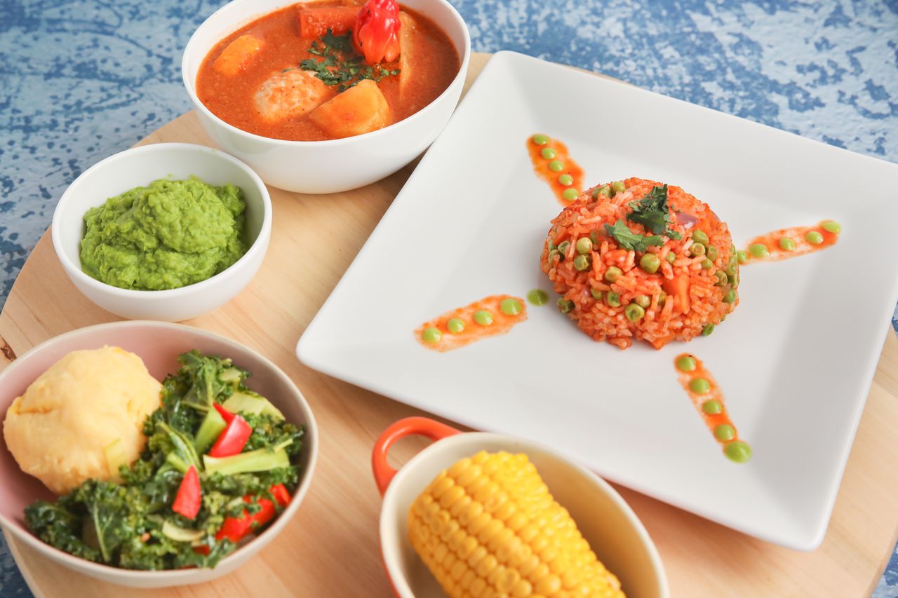 Flat lay of vibrant African dishes including jollof rice and vegetables, ideal for food presentations.
